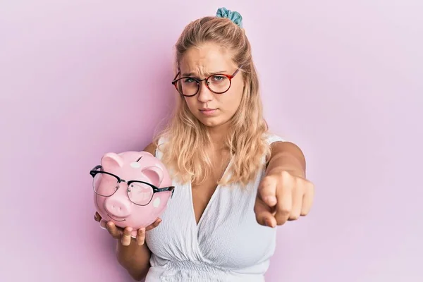 Jong Blond Meisje Holding Piggy Bank Met Bril Wijzend Met — Stockfoto