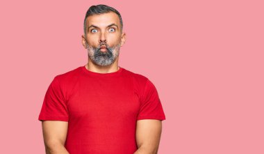 Orta yaşlı, sıradan kıyafetler giyen, dudaklarıyla balık suratı yapan, çılgın ve komik bir jest yapan yakışıklı bir adam. Komik ifade. 