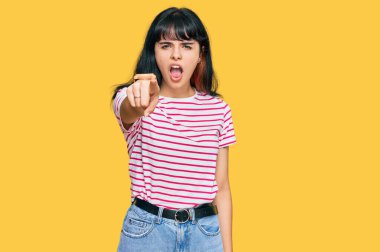 Gündelik kıyafetler giyen genç İspanyol kız kameraya kızgın ve sinirli bir şekilde seni işaret ediyor. 