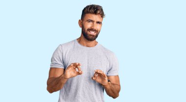 Gündelik kıyafetler giyen genç İspanyol adam tiksindirici bir ifade takınıyor ve tiksindirici bir yüz ifadesi takınıyor.. 