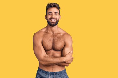 Mayo giyen genç İspanyol adam kollarını kavuşturup kameraya bakarken gülümsüyor. pozitif kişi. 