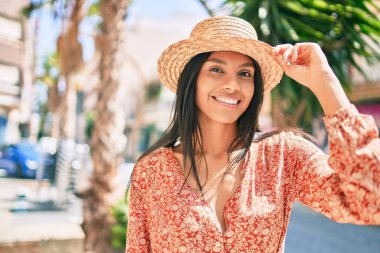 Genç Afro-Amerikan turist kadın tatilde gülümseyerek şehirde mutlu bir şekilde yürüyor..