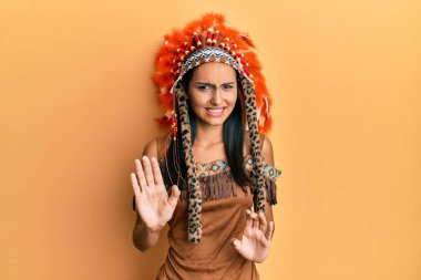 Genç esmer kadın, Hint kostümü giymiş tiksindirici bir ifade takınıyor. Tiksinti tepkisi yüzünden tiksinmiş ve korkmuş bir ifade takınıyor. Eller havada. 