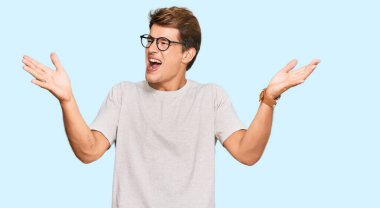 Yakışıklı beyaz bir adam, günlük kıyafetler ve gözlük takmış, çılgın ve çılgın başarısını kutluyor, kolları havada ve gözleri kapalı, heyecanlı çığlıklar atıyor. Kazanan konsept 