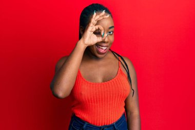 Afro-Amerikalı genç bir kadın kameraya seksi bir ifadeyle, neşeli ve mutlu bir yüzle bakıyor.. 