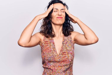 Genç, güzel, İspanyol bir kadın. Elleri başının üstünde, günlük kıyafetler giyiyor. Stres yüzünden baş ağrısı çekiyor. migren ağrısı. 