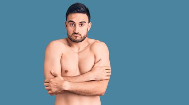 Mayo giyen genç yakışıklı adam kış soğuğu için titriyor ve donuyor. Yüzünde üzgün ve şok edici bir ifade var. 