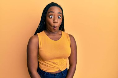 Genç Afro-Amerikalı kadın günlük kıyafetler giyip dudaklarıyla balık suratı yapıyor. Çılgınca ve komik bir jest. Komik ifade. 