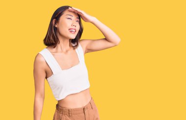 Genç, güzel Çinli bir kız. Günlük kıyafetler giyiyor. Çok mutlu ve gülümsüyor. arama kavramı. 