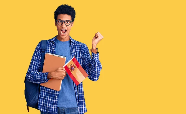 Joven Afroamericano Con Mochila Estudiantil Sosteniendo Bandera Española Gritando Orgulloso —  Fotos de Stock