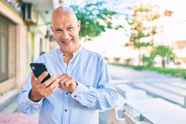 Středního Věku Plešatý Muž Usměvavý Šťastný Pomocí Smartphone Městě — Stock fotografie