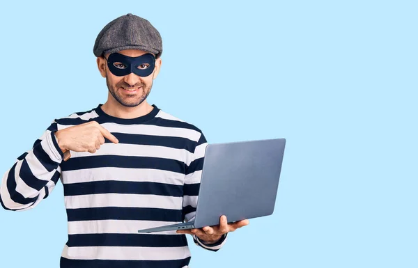 Ung Stilig Man Bär Inbrottstjuv Mask Med Laptop Pekar Finger — Stockfoto