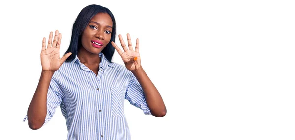 自信を持って幸せな笑顔ながら 若いアフリカ系アメリカ人の女性は カジュアルな服を着て指番号9で示すと指摘します — ストック写真