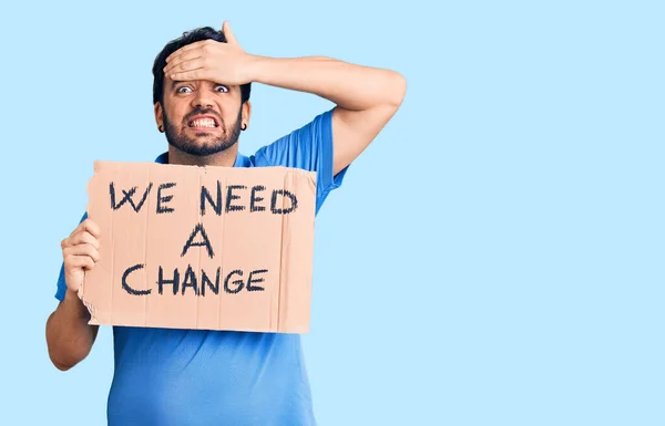 Joven Hombre Hispano Sosteniendo Necesitamos Una Pancarta Cambio Estresado Frustrado —  Fotos de Stock
