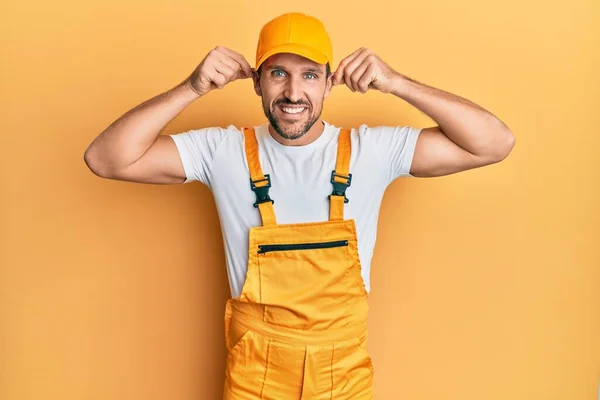 Young Handsome Man Wearing Handyman Uniform Yellow Background Smiling Pulling — 图库照片