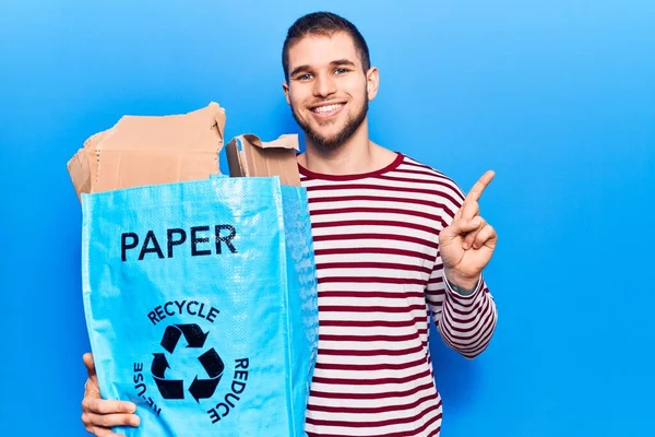 Young Handsome Man Recycling Paper Smiling Happy Pointing Hand Finger — Zdjęcie stockowe