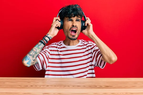 Junger Hispanischer Mann Mit Kopfhörern Der Wütend Und Verrückt Auf — Stockfoto