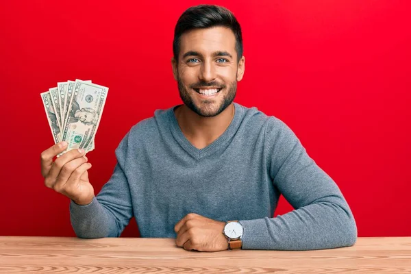 Bonito Homem Hispânico Segurando Notas Dólares Parecendo Positivo Feliz Sorrindo — Fotografia de Stock