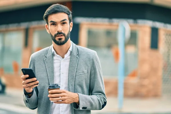 Jonge Spaanse Zakenman Met Serieuze Expressie Met Smartphone Het Drinken — Stockfoto