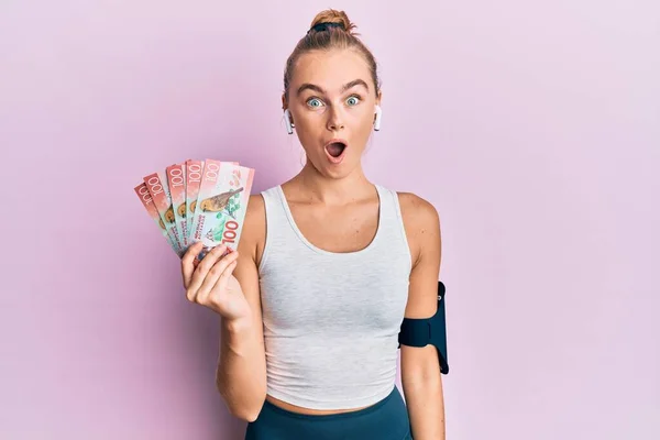 Beautiful Blonde Sport Woman Holding 100 New Zealand Dollars Banknote — Stock Photo, Image