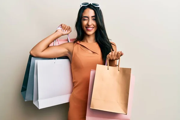 Schöne Hispanische Frau Mit Einkaufstaschen Zwinkernd Die Kamera Blickend Mit — Stockfoto