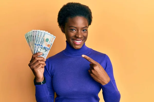 Молода Афроамериканська Дівчинка Яка Тримає Долари Радісно Вказує Пальцем Рукою — стокове фото