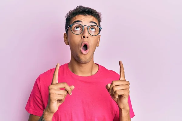 Joven Hombre Afroamericano Guapo Con Gafas Sobre Fondo Rosa Asombrado — Foto de Stock