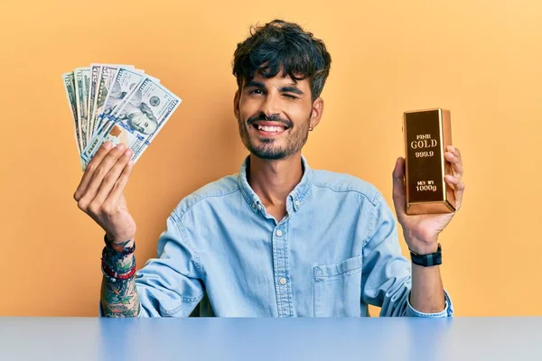 Junger Hispanischer Mann Mit Dollars Und Goldbarren Zwinkernd Die Kamera — Stockfoto