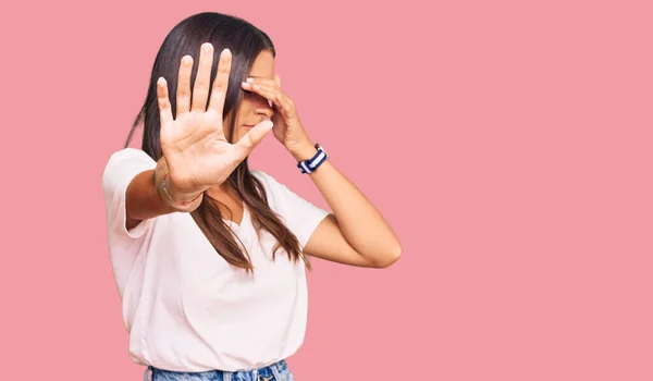 Young Hispanic Woman Wearing Casual White Tshirt Covering Eyes Hands — Stock Photo, Image