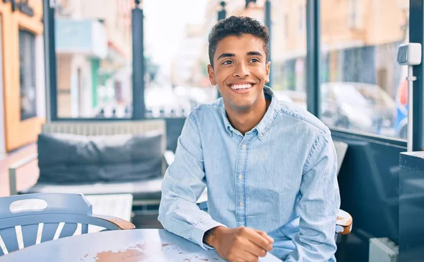 Νεαρός Λατίνος Χαμογελαστός Χαρούμενος Κάθεται Στην Βεράντα Της Καφετέριας — Φωτογραφία Αρχείου