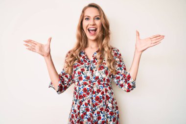 Sarışın, yaz elbisesi giyen genç, beyaz bir kadın çılgın kutlamalar yapıyor ve kolları açık, gözleri açık heyecanla haykırarak başarıyı kutluyor. Kazanan konsept 