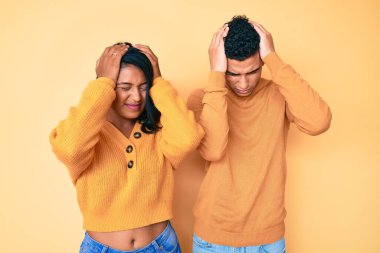 Güzel Latin bir çift, günlük giysiler giyip baş ağrısı çekiyor. Acı ve migren yüzünden çaresiz ve stresli. Eller başının üstünde.. 