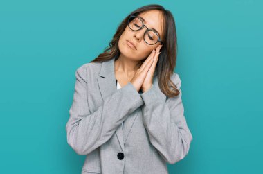 Genç esmer kadın iş kıyafetleri içinde uyuyordu. Yorgun düşler görüyordu ve elleri ile birlikte poz veriyordu. Gözleri kapalı gülümsüyordu.. 