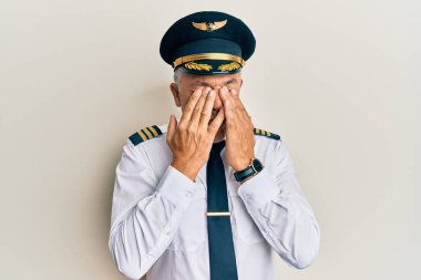 Handsome middle age mature man wearing airplane pilot uniform rubbing eyes for fatigue and headache, sleepy and tired expression. vision problem 