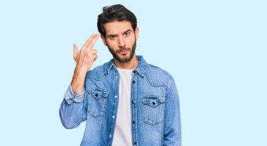 Gündelik giysiler giymiş genç İspanyol bir adam kendini vuruyor ve öldürüyor. Elini ve parmaklarını silah gibi kullanıyor. İntihar jesti.. 