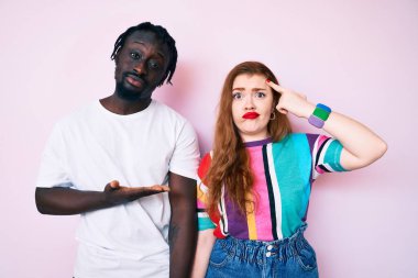 Irklar arası çiftler günlük giysiler giyiyorlar. Avuç içleri açık, fotokopi alanlarını gösteriyorlar ve başlarını parmakla gösteriyorlar. Bunu bir düşün.. 