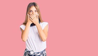 Sarı saçlı, müzik dinleyen, kulaklık takan, ağzı yanlışlıkla ellerle kapatan güzel beyaz bir kadın. gizli kavram. 