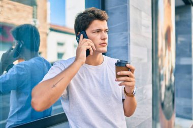 Beyaz adam şehirde akıllı telefon kullanarak mutlu bir şekilde gülümsüyor..