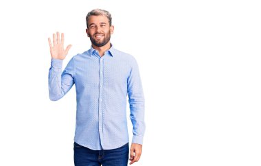 Zarif bir tişört giyen yakışıklı genç adam beş numarayı gösterip işaret ederken kendinden emin ve mutlu bir şekilde gülümsüyor.. 