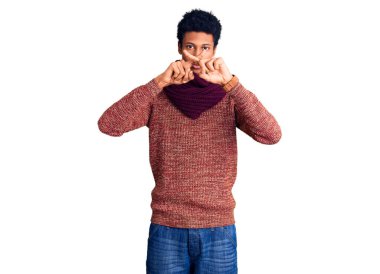 Genç Afro-Amerikan adam günlük kışlık kazak ve atkı reddi ifadesi takıyor. 