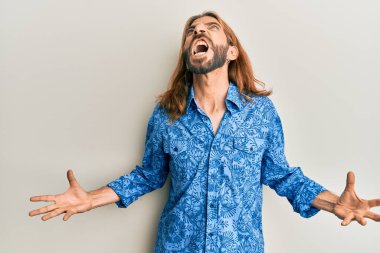 Uzun saçlı ve sakallı çekici bir adam. 80 'lerin disko tarzı tişörtünü giyiyor. Deli gibi bağırıyor, agresif bir ifadeyle bağırıyor ve kollarını kaldırıyor. hüsran kavramı. 