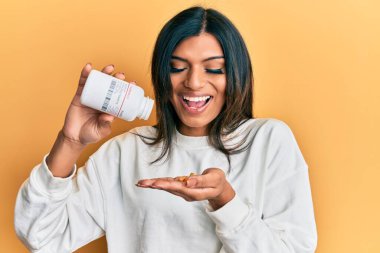 Genç Latin transseksüel kadın elinde haplarla gülüyor ve kahkahalarla gülüyor.. 