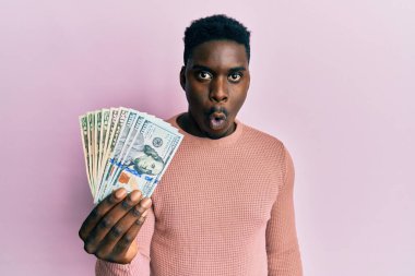 Dolarları tutan yakışıklı siyahi adam. Korkmuş ve ağzı açık kalmış, şaşırmış ve şaşırmış. 