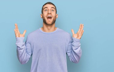 Sıradan kıyafetler giyen genç beyaz adam çılgınlığı kutluyor ve başarıya hayret ediyor kolları açık ve gözleri açık heyecanla haykırıyor. Kazanan konsept 