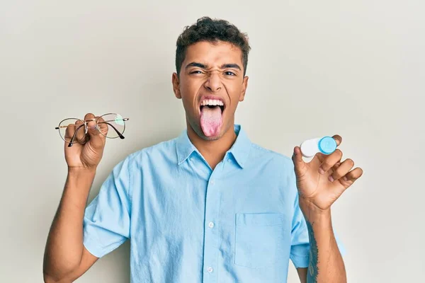 Joven Guapo Afroamericano Hombre Sosteniendo Gafas Lentes Contacto Sacando Lengua —  Fotos de Stock