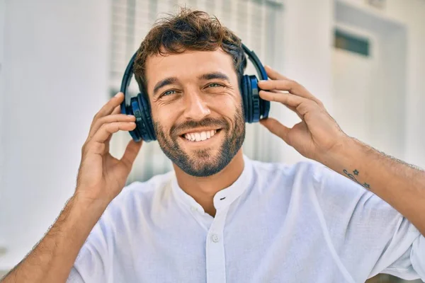 ヘッドフォンを着用し 屋外で音楽を聞いて楽しむ髭を持つハンサムな男 — ストック写真
