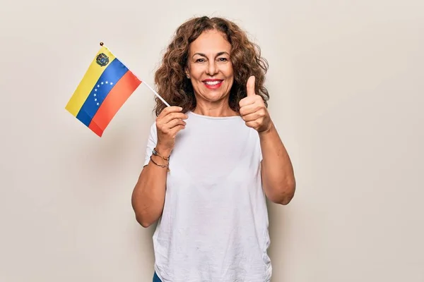 中世の美しい観光の女性を保持Venezuelanフラグ上の隔離された白い背景笑顔幸せと正 親指アップ行う優れた承認サイン — ストック写真