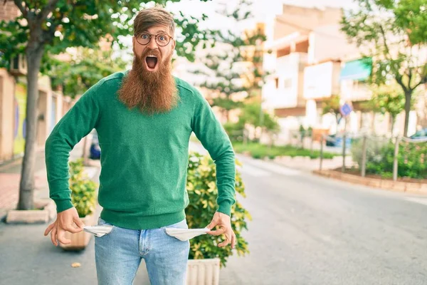 Jovem Irlandês Com Barba Ruiva Surpreso Mostrando Seus Bolsos Vazios — Fotografia de Stock