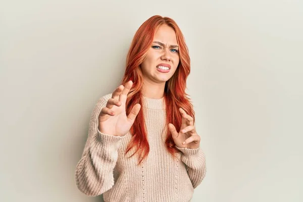 年轻美丽的红头发女人穿着宽松的冬季毛衣 厌恶的表情 不高兴和害怕做厌恶的脸 因为厌恶的反应 举起双手 — 图库照片