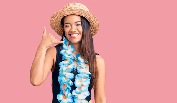 年轻美丽的拉丁女孩戴着夏威夷莱雅 戴着夏帽 微笑着用手和手指做着电话手势 就像在电话里说话一样 交流概念 — 图库照片